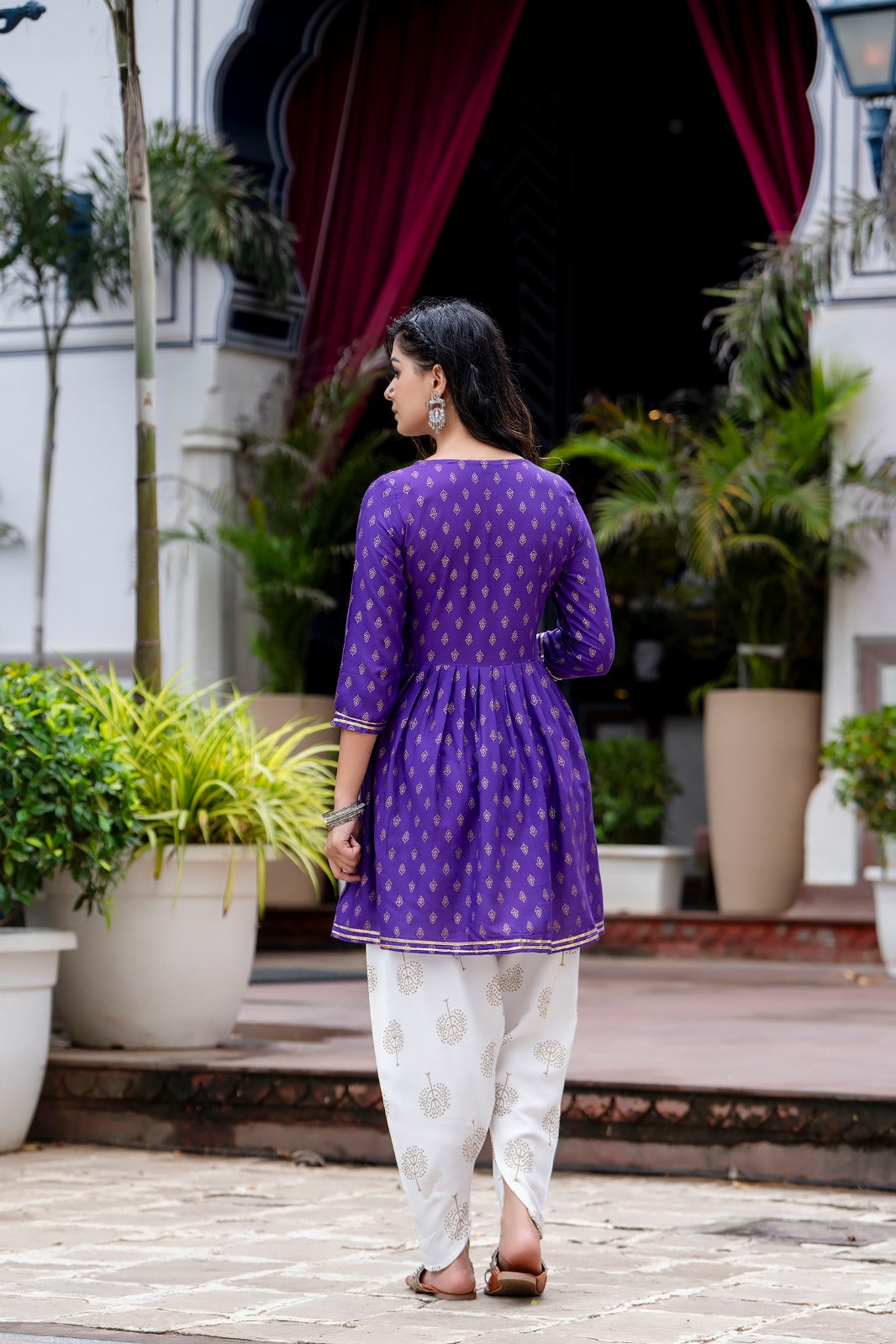 Voilet ethinc motif gold printed kurti with embroidery on yoke and gota lace detailing and gold printed dhoti pant which has full elasticated waistband