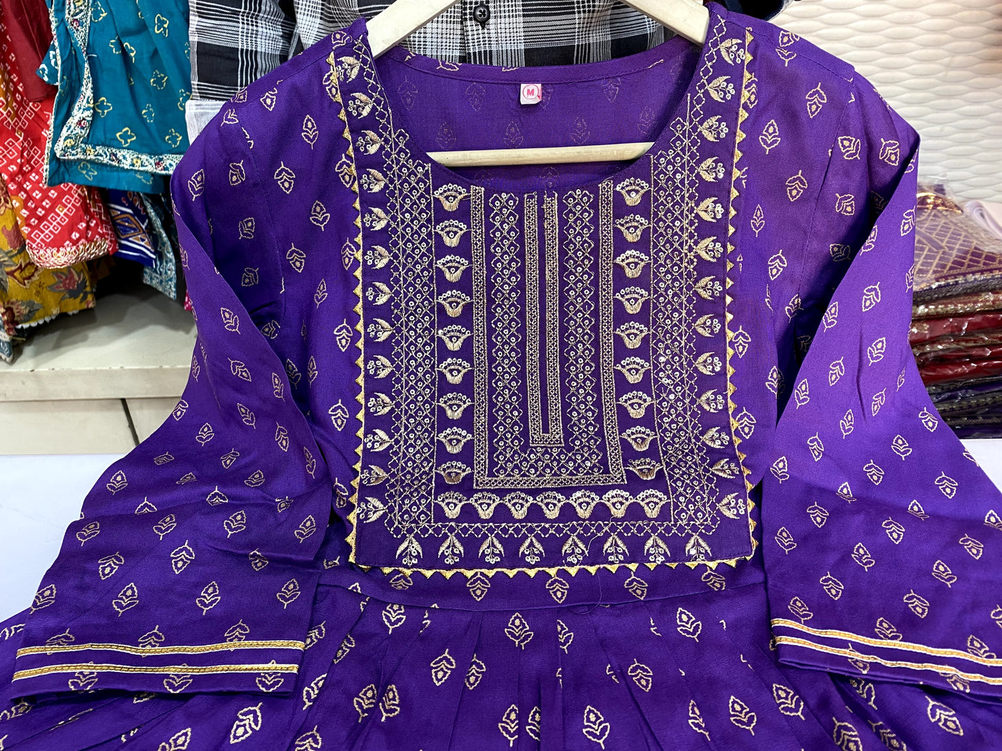 Voilet ethinc motif gold printed kurti with embroidery on yoke and gota lace detailing and gold printed dhoti pant which has full elasticated waistband