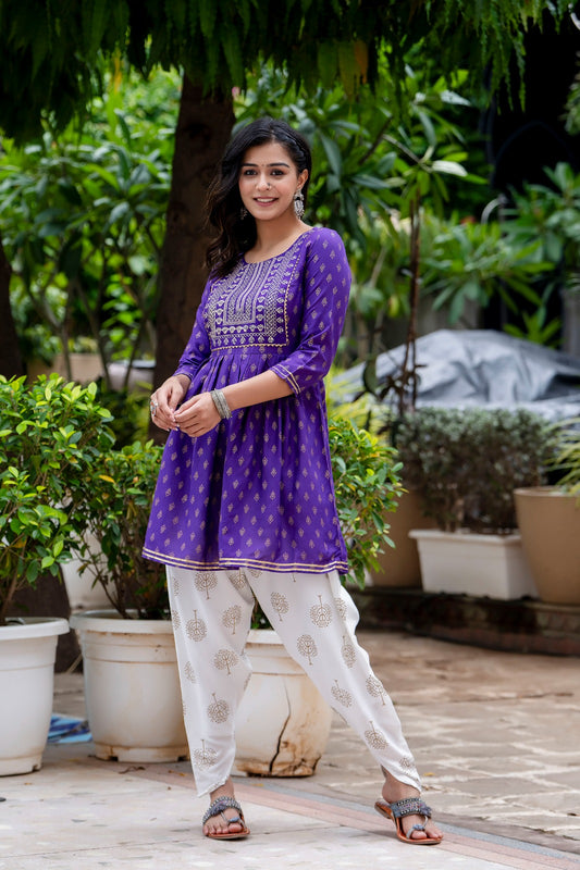 Voilet ethinc motif gold printed kurti with embroidery on yoke and gota lace detailing and gold printed dhoti pant which has full elasticated waistband